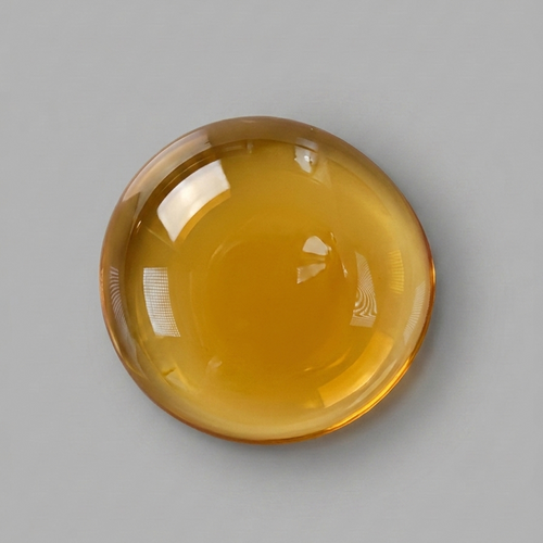 Amber-colored droplet on a gray background